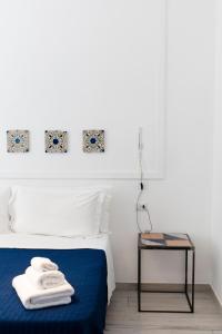 那不勒斯博格威尔日尼花园住宿加早餐旅馆的一间卧室配有一张带蓝色毯子和一张桌子的床。