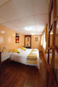 里奥班巴Chimborazo的卧室配有一张白色的大床,铺有木地板