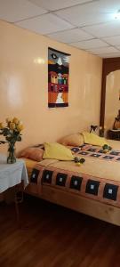里奥班巴Chimborazo的一间卧室配有一张床、一张桌子和一幅画