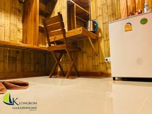 瑶亚岛KLONGBON GARDEN HOME Koh Yao Yai的冰箱旁的木椅