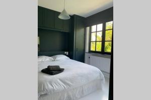 布鲁塞尔Uccle, Pavillon Vert的卧室配有白色的床和窗户。