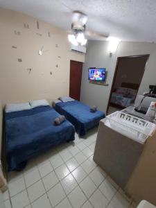 坎昆Casa Soliman - Cancun Centro Market28 Cable TV HBO FOX Netlix的一间卧室设有两张床,墙上配有电视。