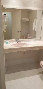 奥瓦尔科德瓦尔德奥拉斯Hospedaje O Camiño的浴室设有粉红色的盥洗盆和镜子