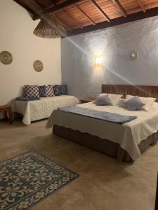 佩德拉斯港Vila Sol Chalés的一间卧室配有两张床,并铺有地毯。