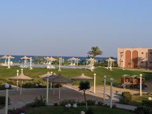 艾因苏赫纳Ain El Sokhna ground floor, with Pool & Sea view的一个带遮阳伞和游乐场的公园