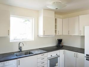 斯特伦斯塔德6 person holiday home in STR MSTAD的厨房配有白色橱柜、水槽和窗户。