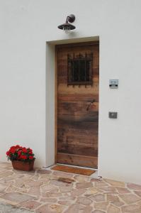 BosentinoB&B Il Crogiolo的木门,带窗户和一盆红花
