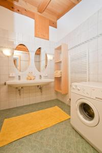 蒂罗尔州圣约翰Vorderstockerhof的一间带洗衣机和两面镜子的浴室