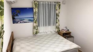 市川市竹内公寓的一间小卧室,配有床和窗户