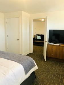 布兰丁Blue Sage Inn & Suites的一间卧室配有一张床和一台平面电视