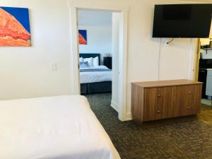 布兰丁Blue Sage Inn & Suites的酒店客房,配有床和电视