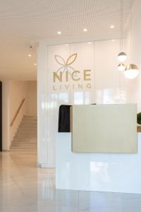 布列瑟农Nice Living Neue- Moderne Apartments im Herzen von Brixen - kostenlose Brixencard - ideal für Familien, Paare, Geschäftsreisende, Gäste mit Hund und allen Urlaubs Hungrigen的白色的大堂,墙上有微微的活标牌