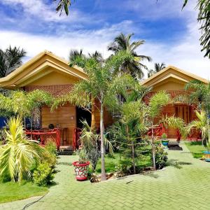 KalladySea View Resort的前面有棕榈树的房子