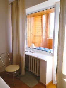 基辅Отдельная комната с балконом в апартаментах, возле м Печерская的窗户,带桌子和椅子的房间