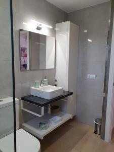 卡拉加尔达纳Garbí & Xaloc apartamentos的白色的浴室设有水槽和镜子