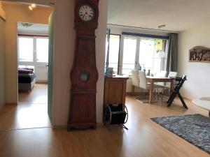 贝阿滕贝格Wohnung mit See und Bergsicht im vier Sterne Hotel的客厅里的大型木制祖父钟