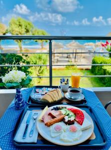 普拉塔尼亚斯卡捷琳娜海滨一室公寓公寓式酒店的一张蓝色桌子,上面放着早餐食品托盘