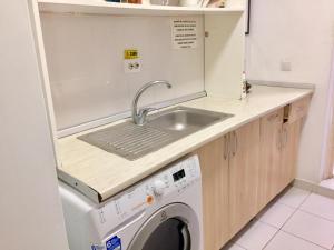 布拉索夫Downtown Hostel的厨房配有水槽和洗衣机
