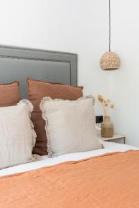 卡拉隆加The Olive Boutique Suites & Spa的一张带棕色和白色枕头的床和一张吊灯