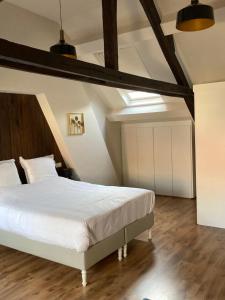 蒂伦豪特RS10 Turnhout的卧室配有一张白色的大床,铺有木地板