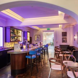 埃克塞特斯奥海之楼酒店的餐厅内的酒吧拥有紫色的灯光