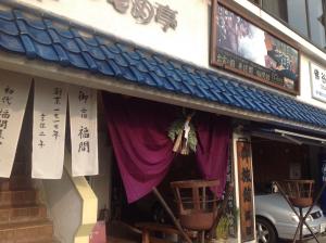 松江市福间馆日式旅馆的建筑前方的商店,布有紫色窗帘