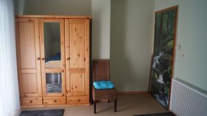 梅特拉赫Helmine的一间卧室配有木制橱柜和椅子