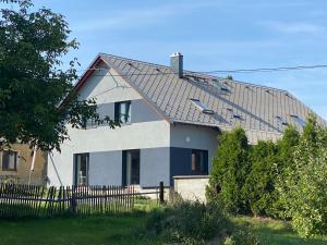 塔霍夫Čtyři pokoje的白色的房子,有黑色的屋顶和栅栏