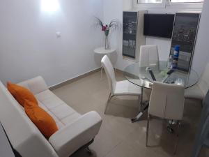 马拉加马可德拉麦西德公寓的客厅配有玻璃桌和白色椅子