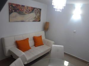 马拉加马可德拉麦西德公寓的客厅配有带橙色枕头的白色沙发