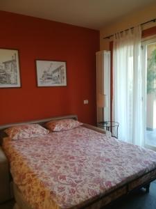 坎诺比奥卡希纳莱博斯科公寓式酒店的一间卧室配有一张带橙色墙壁和窗户的床