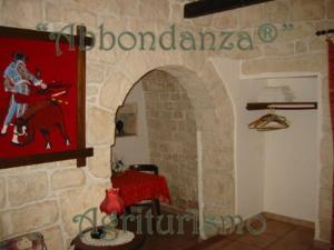 阿尔贝罗贝洛Abbondanza® Agriturismo的一间设有红色绘画的石墙客房