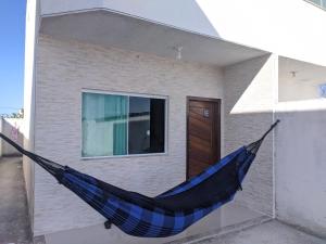 卡波布里奥Duplex Cabo frio I的挂在房子外的蓝色吊床