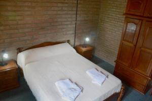 米娜克拉韦罗LA TOMA Complejo de Montaña - Cabañas y Habitaciones en Hosteria的一间卧室配有一张床,上面有两条毛巾