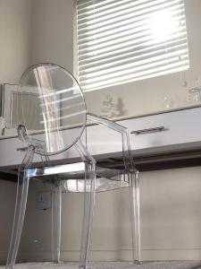 兰格班Views at 69 B&B的一张透明的玻璃椅子坐在桌子上