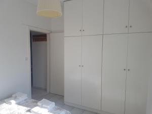 拉里萨NN Larisa Deluxe Apartment的白色客房,地板上配有白色橱柜和毛巾