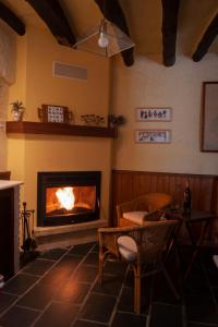 特雷韦莱斯Casa-Huerto La Juana的客厅设有壁炉、桌子和椅子