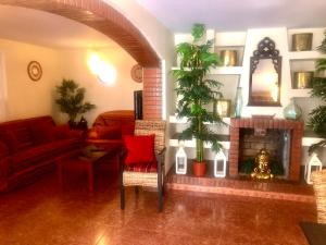 滨海罗克塔斯GRAN CASA con TERRAZA a 3 min Playa con Wifi - rodeada de servicios的客厅设有壁炉和红色沙发。