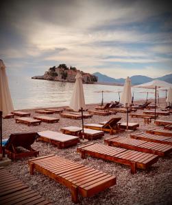 斯韦蒂·斯特凡Sound of the Sea Apartment的海滩上的一组躺椅和遮阳伞