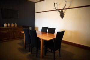 WaimateMakikihi Country Hotel的一间带木桌和椅子的用餐室