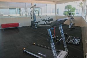 泗水Choice City Hotel的健身房设有跑步机和数辆健身自行车