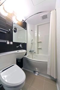 札幌KOKO HOTEL Sapporo Ekimae的浴室配有白色卫生间、浴缸和水槽。