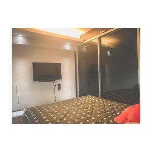 峇六拜The ceo suites by Zenbnb的一间卧室配有一张床和一台平面电视