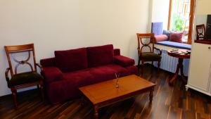 敖德萨Затишні апартаменти, вулиця Дерибасівська, 13的客厅配有红色的沙发和两把椅子
