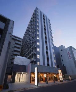 鹿儿岛KOKO HOTEL Kagoshima Tenmonkan的一座高大的建筑,有建筑