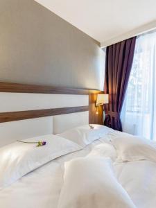 波亚纳布拉索夫新宫米鲁娜酒店的一张带两个白色枕头的床和窗户