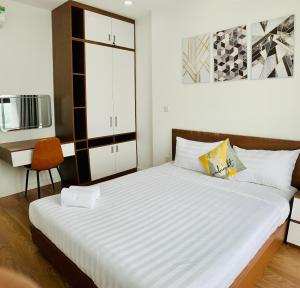 河内Asahi Luxstay - D'el Dorado Apartment的一间卧室配有一张大床和一把椅子