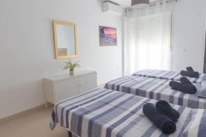 卡沃内拉斯Casa Elena - Cabo de Gata的蓝色和白色条纹间内的两张床