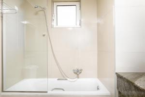 卡尔扎迈纳君主海滩酒店的白色的浴室设有浴缸和窗户。
