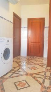 桑卢卡尔-德巴拉梅达Casa Algarabía的一间洗衣房,配有洗衣机和瓷砖地板